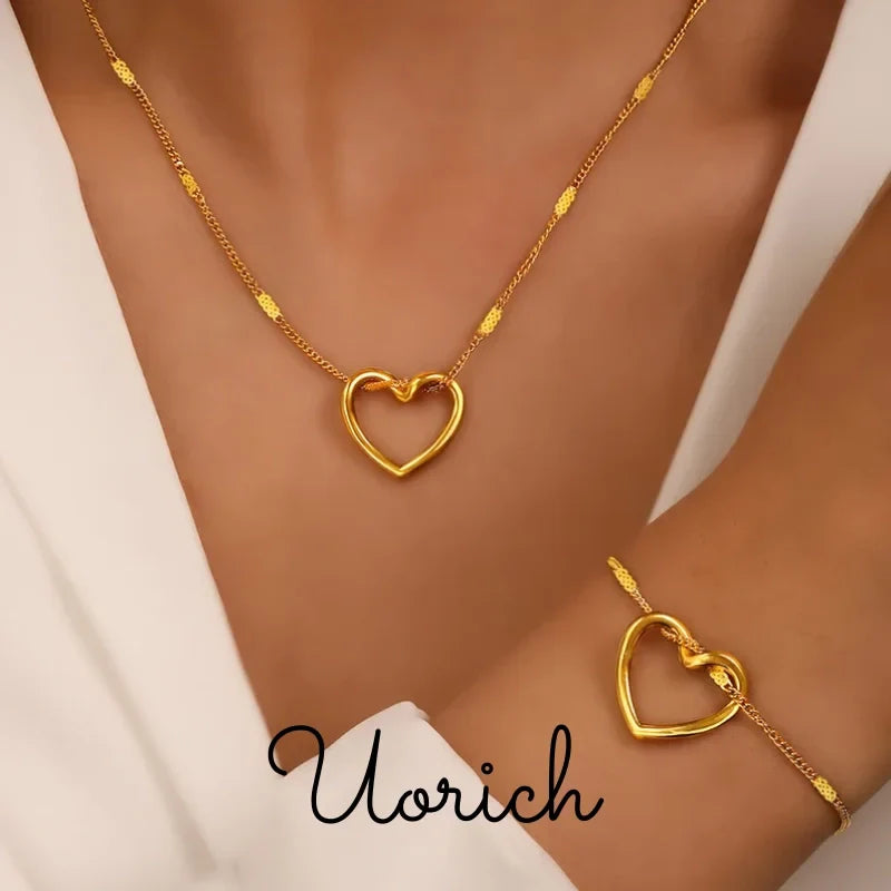 Parure de bijoux en or : collier et bracelet assortis avec pendentif cœur évidé et chaîne maille gourmette fine.