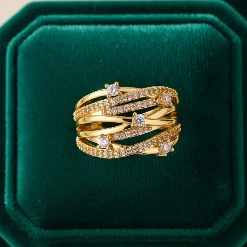 Grosse bague dorée multi-rangs entrelacée sertie de strass portés à l'annulaire d'une femme - Style chic et festif