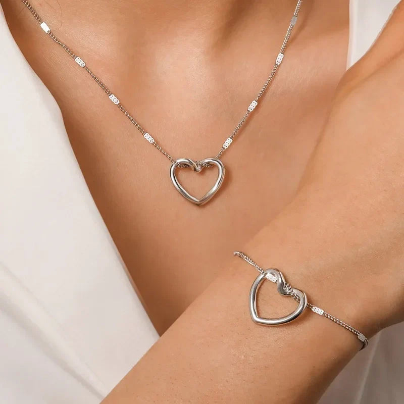 Parure de bijoux en argent : collier et bracelet assortis avec pendentif cœur évidé et chaîne maille gourmette fine.