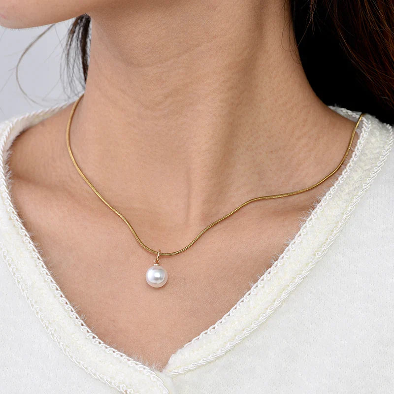 Collier en or solitaire perle de culture porté autour du cou
