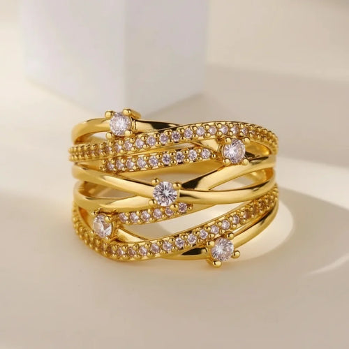Grosse bague dorée multi-rangs entrelacée sertie de strass portés à l'annulaire d'une femme - Style chic et festif