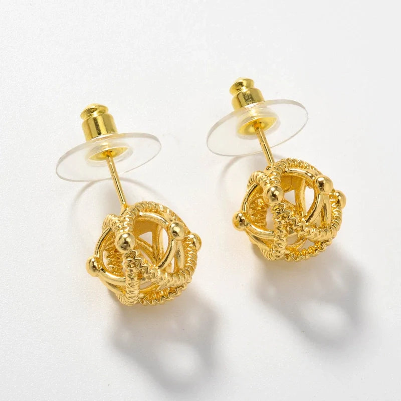 Boucles d'oreilles puces dorées en forme de sphères entrelacées texturées, design géométrique et style vintage.